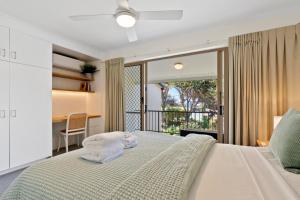 日出海滩海滩客度假酒店的一间卧室配有带毛巾的床