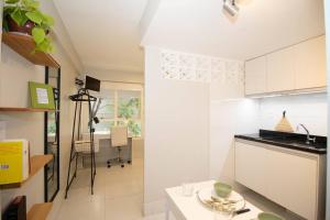 巴西利亚Studio na melhor quadra da Asa Norte的厨房配有白色橱柜和桌子