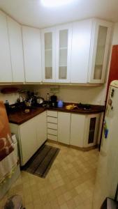 巴西利亚Apartamento SQN 407的厨房配有白色橱柜和瓷砖地板。
