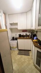 巴西利亚Apartamento SQN 407的厨房配有白色橱柜和水槽