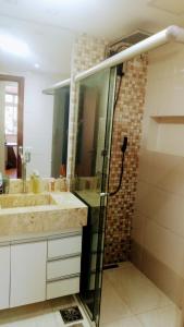 巴西利亚Apartamento SQN 407的一间带两个水槽和玻璃淋浴间的浴室