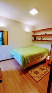 巴西利亚Apartamento SQN 407的一间卧室设有绿色的床,铺有木地板