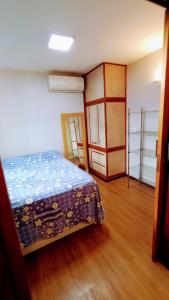 巴西利亚Apartamento SQN 407的一间卧室配有一张床,铺有木地板