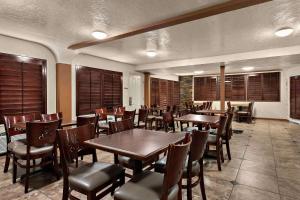 圣乔治南布拉夫品质酒店的餐厅设有木桌、椅子和窗户。