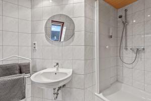 LudwigshafenFamily&Friends 2的白色的浴室设有水槽和淋浴。
