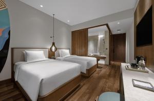 坎古Holiday Inn Resort Bali Canggu, an IHG Hotel的酒店客房带两张床和一间浴室