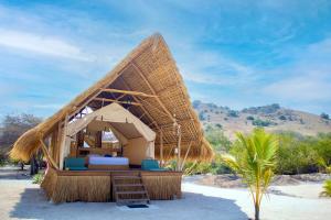纳闽巴霍Le Pirate Island - Adults Only的一个带床和茅草屋顶的度假村