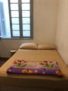阿雷格里港Hostel Bahia的床上有鲜花的毯子