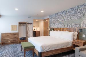 班夫Hotel Canoe and Suites的卧室配有一张白色大床和一把椅子