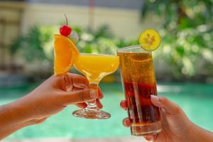 库塔Bali Summer Hotel by Amerta的两人手持两杯饮料