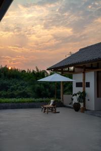 长宁宜宾蜀南竹海.蜀山南左岸度假民宿的一个带长凳和遮阳伞的庭院