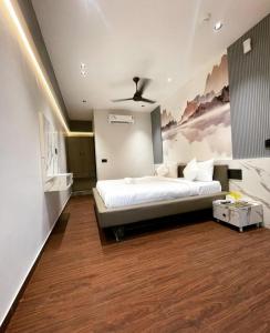 苏拉特V Love Hotel的卧室配有一张床,墙上挂有绘画作品