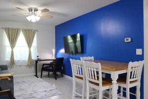 莱克兰Hidden Sapphire-Apartment with Kitchen and Laundry的一间设有蓝色墙壁和桌椅的用餐室