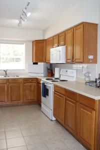莱克兰Hidden Sapphire-Apartment with Kitchen and Laundry的厨房配有木制橱柜和白色炉灶烤箱。