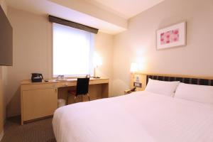 仙台KOKO HOTEL Sendai Station West的配有一张床、一张书桌和一扇窗户的酒店客房