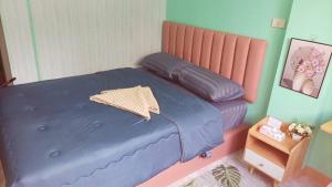巴吞他尼Jatuporn A1的一间卧室配有一张带蓝色棉被的床