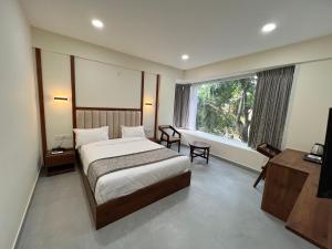 班加罗尔Vrishi Inn的酒店客房设有床和窗户。