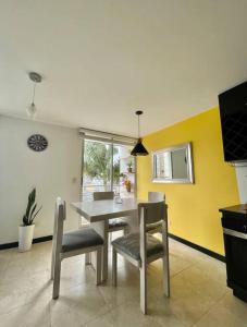 马尼萨莱斯Exclusivo Apartamento en Av. Santander的用餐室配有桌椅和黄色墙壁