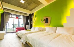 小琉球岛朵猫猫海景民宿的绿墙客房的两张床