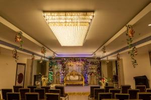 TinsukiaPalm Resorts的一个带一张床和吊灯的宴会厅