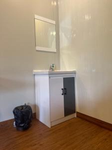 科钦WHOOSH HOMES的一间设有白色橱柜和墙上镜子的房间