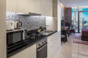 迪拜DAMAC Maison Aykon City Dubai的厨房配有炉灶和微波炉。