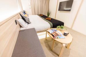 大阪Apartment Hotel 11 Kuromon的一间卧室配有一张床、一张桌子和一台电视。