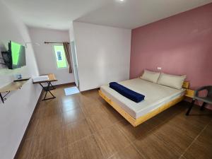 罗勇Klong Zand Resort的一间卧室配有一张床、一张书桌和一台电视。