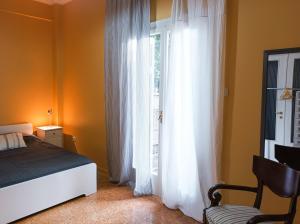 雅典Beautiful house in Chalandri的一间卧室配有床和白色窗帘的窗户