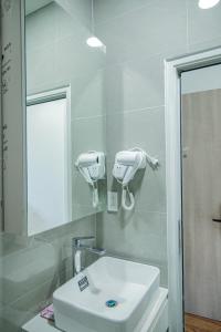 边和The Mansion Hotel Bien Hoa的浴室设有白色水槽和镜子