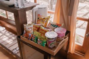 大叻Mơ Garden Retreat DaLat的架子上放着一大堆小吃和冰箱