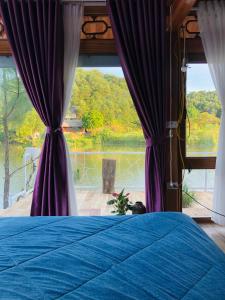 河内Nha Ben Ho Venuestay的一间卧室配有蓝色的床,享有湖景