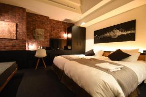 东京赤阪觉醒酒店的一间卧室设有一张大床和砖墙