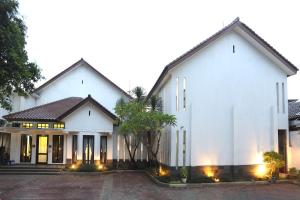 雅加达ARCS House Menteng by Jambuluwuk的一座白色的大房子,灯火通明