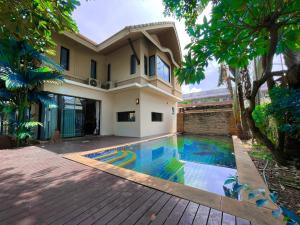 芭堤雅市中心Baan Natcha Villa的一座房子前面设有游泳池