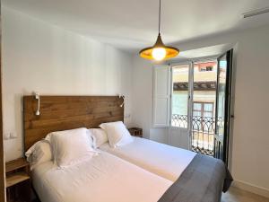 毕尔巴鄂7芥兰住宿加早餐旅馆的卧室设有一张白色大床和一扇窗户。