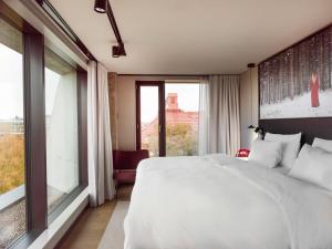 赫尔辛基Radisson RED Helsinki的卧室设有白色的床和大窗户
