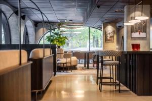 赫尔辛基Radisson RED Helsinki的餐厅设有酒吧,配有桌椅