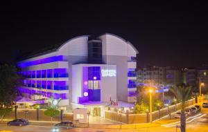 阿拉尼亚蓝波套房酒店的一座在晚上装有紫色门的大建筑