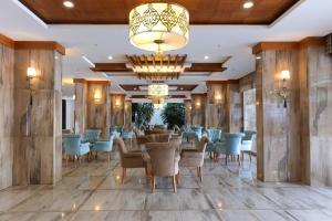 阿拉尼亚蓝波套房酒店的一间带桌椅和吊灯的用餐室