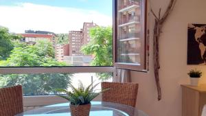 毕尔巴鄂Mood Bilbao Apartamentos - New & Special的一间设有玻璃桌和窗户的用餐室