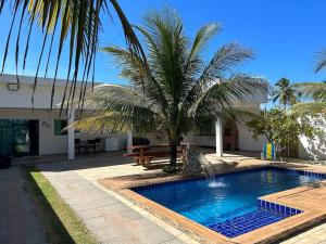 Barra do SirinhaémBeachhouse in Barra do Sirinhaém的一座游泳池,旁边是一座棕榈树
