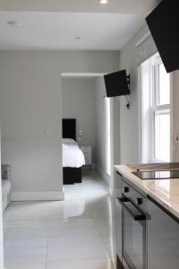 贝尔法斯特MOXIE LUXURY APARTMENTS的白色的厨房,后面配有一张床