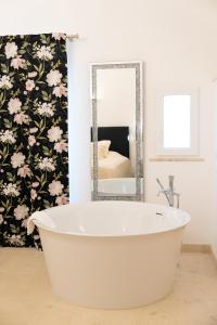 艾因西莱姆The White Knight Premium Boutique Hotel的浴室设有白色浴缸及镜子
