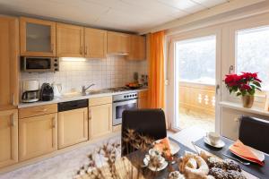 圣加伦基希青特公寓的厨房配有木制橱柜、桌子和窗户。