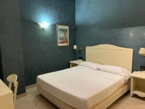 那不勒斯Hotel Serena的卧室配有白色的床和蓝色的墙壁