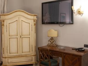 那不勒斯Hotel Serena的客房设有书桌和墙上的电视。