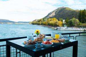维谢格拉德Aquamarina Hotel Visegrád的阳台上的餐桌,享有水景