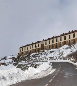 巴尔德利纳雷斯Casa Majo Valdelinares VUTE-23-002的一座有道路的雪覆盖的山丘上的建筑