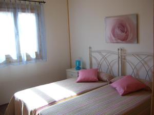 AlcanadreVivienda de uso turístico Fuente Vilda VT-LR 0033的一间卧室配有带粉红色枕头的床。